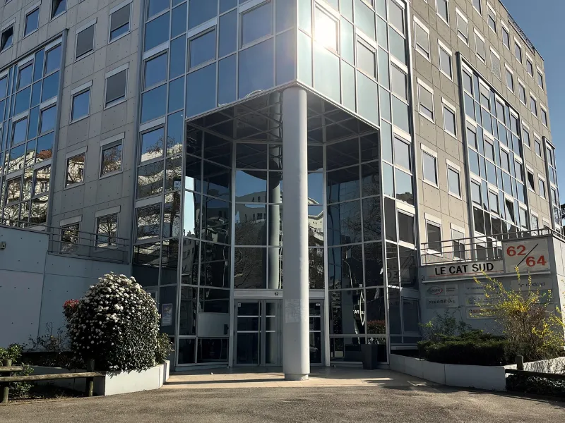 Façade vitrée moderne de l'immeuble de bureaux Le Cat Sud avec entrée sécurisée et accès parking.