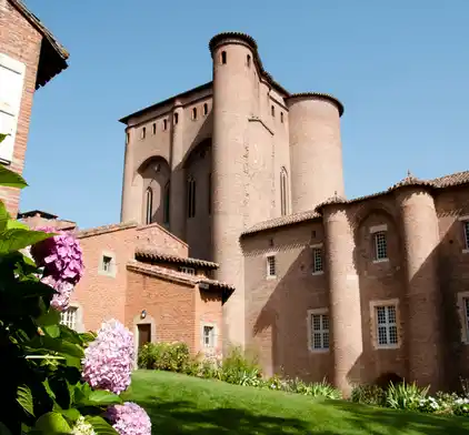 Vue extérieure du Palais de la Berbie à Albi avec ses tours en briques rouges et ses jardins fleuris