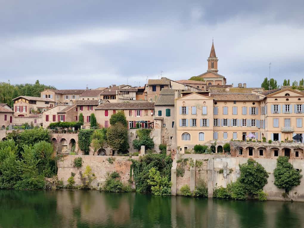 Maisons aux façades colorées et architecture typique surplombant les rives verdoyantes du Tarn à Albi.
