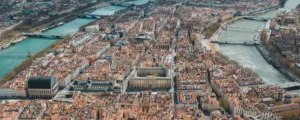 Vue aérienne panoramique de Lyon montrant la confluence de la SaÎne, le quartier du Vieux Lyon au pied de la colline de FourviÚre et la basilique dominant la ville.