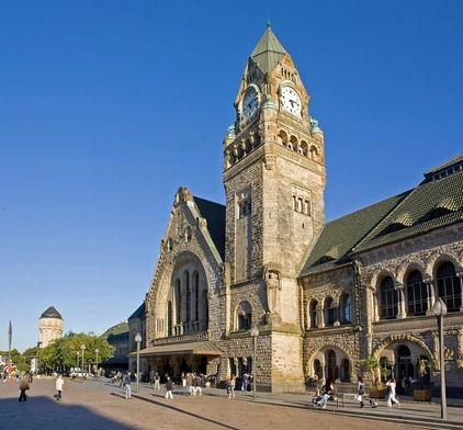 Façade historique de la Gare de Metz-Ville avec sa tour de l'horloge et son architecture néo-romane en pierre de Jaumont.