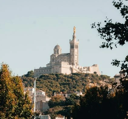 Gros plan sur l'architecture de la basilique Notre-Dame de la Garde et sa statue dorée, repère spirituel et géographique de Marseille, visible depuis certains espaces de coworking à Marseille.