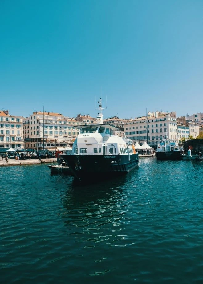 The 'Edmond Dantès' river shuttle cruises the turquoise waters of Marseille's Vieux-Port, connecting neighborhoods for coworking users in Marseille.