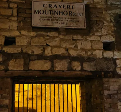 Commemorative plaque above an illuminated former chalk pit, testifying to the strong economic and wine-growing heritage of the Reims region.