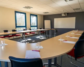 Salle de réunion en U avec tableau blanc et vidéoprojecteur au centre d'affaires BURO Club Le Mans