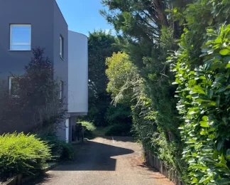 Allée d'accès au centre d'affaires, un environnement calme et bordé de verdure.