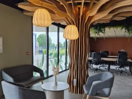 Espace détente et coworking avec canapés et décoration en bois naturel au design d'arbre à Niort.