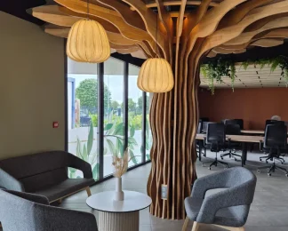 Espace détente et coworking avec canapés et décoration en bois naturel au design d'arbre à Niort.