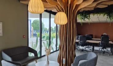 Espace détente et coworking avec canapés et décoration en bois naturel au design d'arbre à Niort.