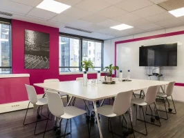Salle de réunion "Ile flottante" lumineuse toute équipée avec écran et mur rose, en location au BURO Club Partner Boulogne.