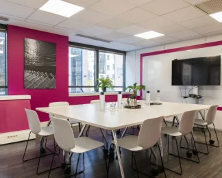 Salle de réunion "Ile flottante" lumineuse toute équipée avec écran et mur rose, en location au BURO Club Partner Boulogne.