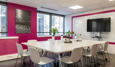 Salle de réunion "Ile flottante" lumineuse toute équipée avec écran et mur rose, en location au BURO Club Partner Boulogne.