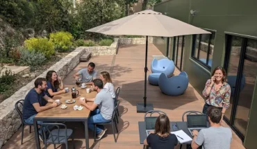 Terrasse aménagée du centre d'affaires BURO Club Partner Aix Éguilles avec mobilier de jardin, parasol et coworkers travaillant en extérieur.