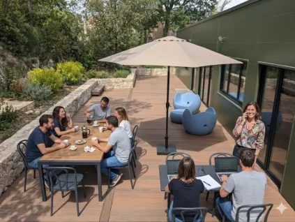 Terrasse aménagée du centre d'affaires BURO Club Partner Aix Éguilles avec mobilier de jardin, parasol et coworkers travaillant en extérieur.