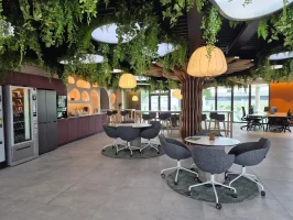 Espace de vie convivial avec cuisine équipée, plafond végétalisé et espaces de coworking au BURO Club Partner Niort.