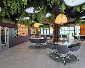 Espace de vie convivial avec cuisine équipée, plafond végétalisé et espaces de coworking au BURO Club Partner Niort.