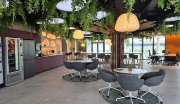 Espace de vie convivial avec cuisine équipée, plafond végétalisé et espaces de coworking au BURO Club Partner Niort.