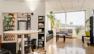 Espace détente lumineux avec distributeurs et coin salon au centre d'affaires BURO Club Nancy