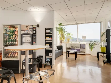 Espace détente lumineux avec distributeurs et coin salon au centre d'affaires BURO Club Nancy