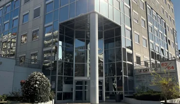 Façade vitrée moderne de l'immeuble de bureaux Le Cat Sud avec entrée sécurisée et accès parking.