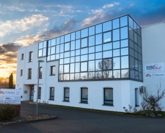 Façade vitrée du centre d'affaires BURO Club Le Mans au coucher du soleil