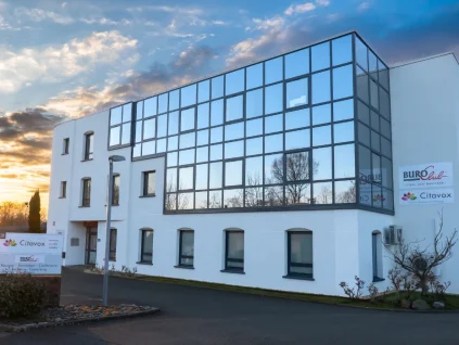 Façade vitrée du centre d'affaires BURO Club Le Mans au coucher du soleil