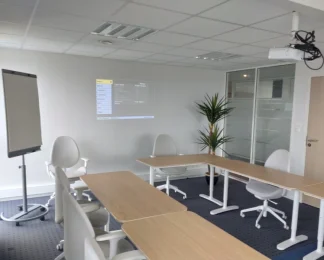 Grande salle de séminaire disposée en U avec écran de projection au centre d'affaires de Vannes.