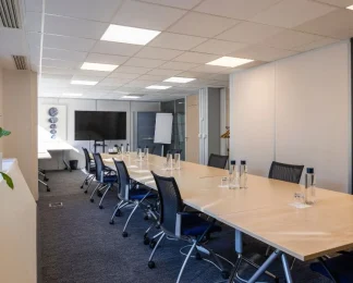 Grande salle de réunion "Ile aux moines" spacieuse avec table en bois et équipement audiovisuel pour vos séminaires à Boulogne-Billancourt.