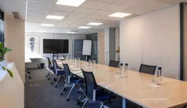 Grande salle de réunion "Ile aux moines" spacieuse avec table en bois et équipement audiovisuel pour vos séminaires à Boulogne-Billancourt.