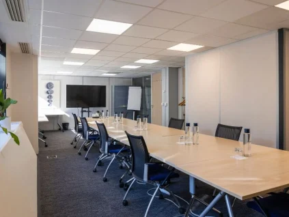 Grande salle de réunion "Ile aux moines" spacieuse avec table en bois et équipement audiovisuel pour vos séminaires à Boulogne-Billancourt.