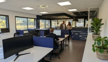 Espace de coworking moderne à Aix-en-Provence Éguilles avec bureaux partagés, séparateurs acoustiques bleus et zone d'accueil.