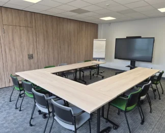 Salle de réunion aménagée en U pour séminaires avec écran et paperboard au centre d'affaires de Niort.