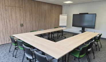 Salle de réunion aménagée en U pour séminaires avec écran et paperboard au centre d'affaires de Niort.