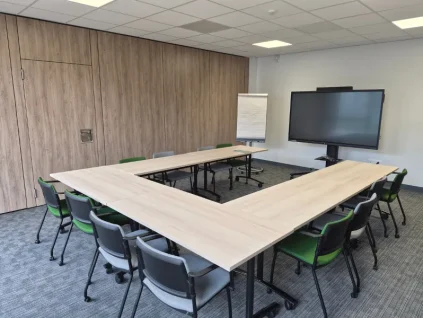Salle de réunion aménagée en U pour séminaires avec écran et paperboard au centre d'affaires de Niort.