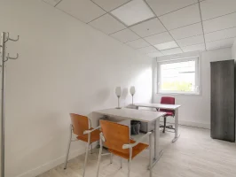 Location de bureau équipé pour deux personnes avec bureaux blancs, chaises ergonomiques et portemanteau.