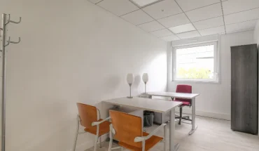 Location de bureau équipé pour deux personnes avec bureaux blancs, chaises ergonomiques et portemanteau.