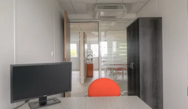 Intérieur de bureau professionnel avec cloisons vitrées, climatisation et mobilier moderne prêt à l'emploi.