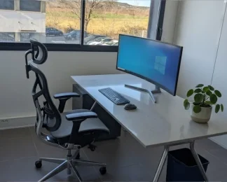 Poste de travail ergonomique chez BURO Club Partner Aix Éguilles avec fauteuil de bureau haut de gamme, écran incurvé et vue dégagée.