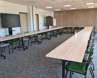 Grande salle de formation lumineuse en U équipée de doubles écrans interactifs chez BURO Club Partner Niort.