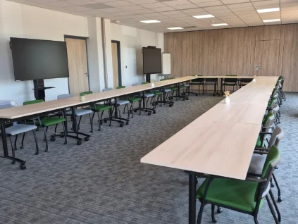 Grande salle de formation lumineuse en U équipée de doubles écrans interactifs chez BURO Club Partner Niort.