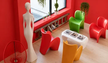 Espace lounge coloré au BURO Club Partner Beaune avec murs rouges, fauteuils design contemporains multicolores et baies vitrées.