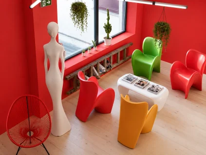 Espace lounge coloré au BURO Club Partner Beaune avec murs rouges, fauteuils design contemporains multicolores et baies vitrées.