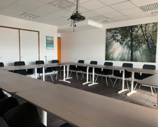 Grande salle de réunion équipée d'un vidéoprojecteur et aménagée en U chez BURO Club Vannes