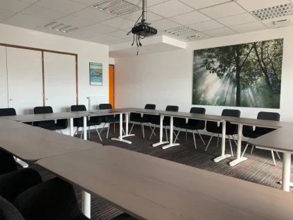 Grande salle de réunion équipée d'un vidéoprojecteur et aménagée en U chez BURO Club Vannes