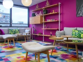 Espace lounge chaleureux et coloré avec canapés, idéal pour les pauses au sein du centre d'affaires BURO Club Partner Boulogne.