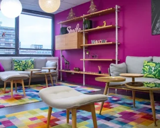 Espace lounge chaleureux et coloré avec canapés, idéal pour les pauses au sein du centre d'affaires BURO Club Partner Boulogne.
