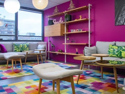 Espace lounge chaleureux et coloré avec canapés, idéal pour les pauses au sein du centre d'affaires BURO Club Partner Boulogne.