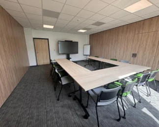Configuration en U d'une salle de conférence spacieuse avec cloisons boisées au BURO Club Partner Niort.