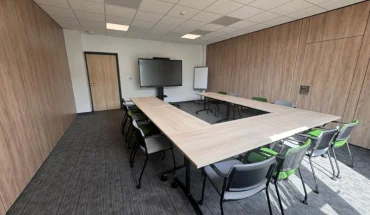 Configuration en U d'une salle de conférence spacieuse avec cloisons boisées au BURO Club Partner Niort.