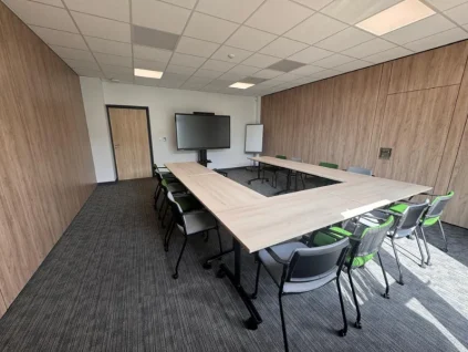 Configuration en U d'une salle de conférence spacieuse avec cloisons boisées au BURO Club Partner Niort.